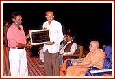 As part of the dedication ceremony, Swamishri offers a plaque to leading members of each village school