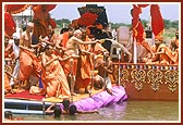 Swamishri sprinkles the sanctified water into the river and on the sadhus