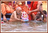 Swamishri gently releases Shri Ganeshji in to the waters of the river Utavali