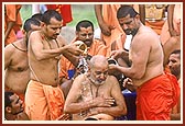 Attendant sadhus then bathe Swamishri with clean tap water