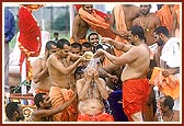 Attendant sadhus then bathe Swamishri with clean tap water