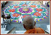 Swamishri looks at the colorful and artistic rangoli done by the devotees