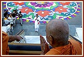 Swamishri looks at the colorful and artistic rangoli done by the devotees