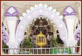 Thermocol-decorated arched gate with motorized swinging & rotating hindolo at center. Amdavad