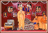 While standing, Swamishri blesses the assembly