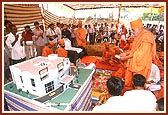 Swamishri performs arti of Thakorji placed by the model of the planned Pramukh Swami Institute of Information Technology (PIIT)