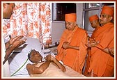 Swamishri blesses ailing devotees and prays for their quick recovery during his visit in a hospital