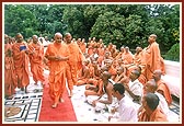 Swamishri shares a light moment with sadhus while circumambulating the Yagnapurush Smruti Mandir