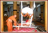 Swamishri reverentially touches the palanquin that carried Shastriji Maharaj's body for the last rites