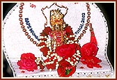 Shri Harikrishna Maharaj adorned in clothes with logo of Bal-Kishore shibir 2002