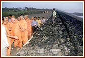 Swamishri observes the specially made wall of stones by the ocean-shore