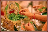 Swamishri offers tulsi leaves to Shri Harikrishna Maharaj during recital of the Janmangal Namavali - the 108 names of Bhagwan Swaminarayan