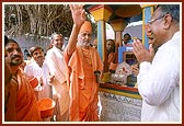 Swamishri sprinkles the sanctified water on the devotees present