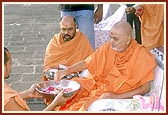 Swamishri performs the rites of asthi (bone relics) of the late Amra Bapu of Paliyad before immersing them in the holy river Gondali