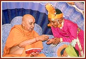 Swamishri gives prasad to a balak