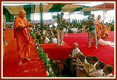 Swamishri blesses the devotees by showering rice grains