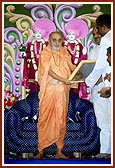 An official of the Municipality of Surendranagar presents a citation of honor to Swamishri