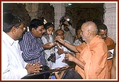 Swamishri gives water to even a balak during a ritual