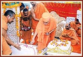 Swamishri performs pujan of pillar and fills the pillar base with cement