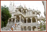 Sadhus and devotees climb the mandir stairs for darshan