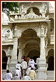 Sadhus and devotees climb the mandir stairs for darshan