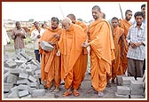 Swamishri examines cement blocks manufactured at the mandir