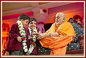 Swamishri garlands two young school children