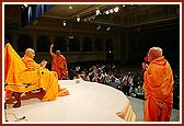 Ghanshyamcharan Swami and Krishnapriya Swami sing bhajans during the eclipse assembly