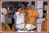 Swamishri engages a child in performing abhishek of Shri Nilkanth Varni