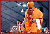 Swamishri adds ghee to the sacrificial fire
