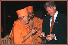 President Clinton marvels at the rosary presented to him by Swamishri. He is impressed by Swamishri's faith in the power of prayer to promote world peace
