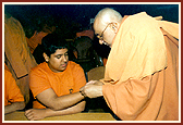 Atmaswarup Swami ties rakhadi on the wrist of a kishore