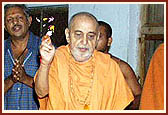 Swamishri showers flower petals and sanctifies the jalebi for Annakut prasad