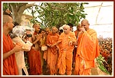 After nearly 2 hours of spraying colored, holy water on every devotee present, Swamishri takes leave