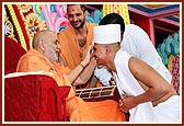 Swamishri blesses and gives the guru mantra to the newly initiated sadhus and parshads