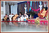 Swamishri blesses the conference, with senior scholars and invited guests seated on stage