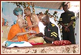 Swamishri gives vartman to the security guard who gave up meat and alcohol