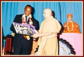 Swamishri presents a souvenir photo to Uhuru Kenyatta, Leader of the Opposition Party
