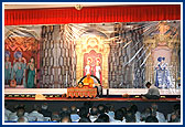 Swamishri's morning puja with a backdrop of murtis and three shrines of Bochasan Mandir