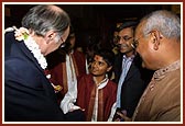 Michael Howard, former Home Secretary, talking to a BAPS child volunteer who sang the Shanti Paath