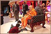 Swamishri being welcomed by two young students 
