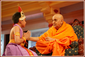 Swamishri speaks to a child who performed a solo dance