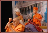 Swamishri applying the tilak mark on his forehead