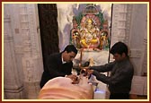 Devotees offering their devotion by performing abhishek of the Shivling with milk and bilipatras