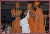 A balak applies a chandlo to Swamishri's forehead