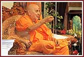 Swamishri teaches children how to do the mala properly