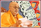 Swamishri reads letters during the evening assembly