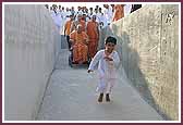  A balak joyously runs in front of Swamishri as he leaves the Mandir 