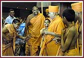 Balaks dressed as saints receive Swamishri to the Swagat Sabha 