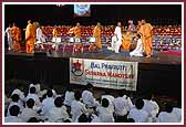 Balaks dressed as saints receive Swamishri to the Swagat Sabha